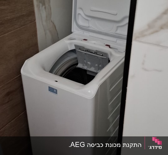 מכונת כביסה פתוחה עם דלי צבעוני ליד